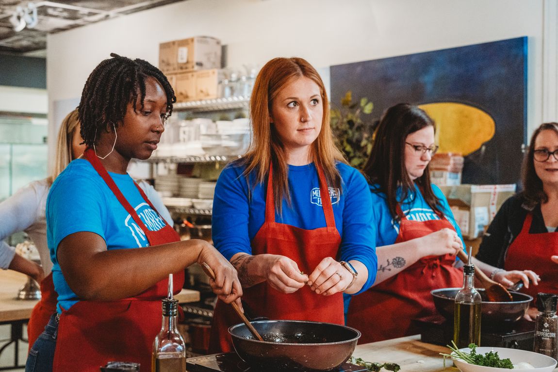 A corporate team making fresh pasta together at The Local Epicurean.