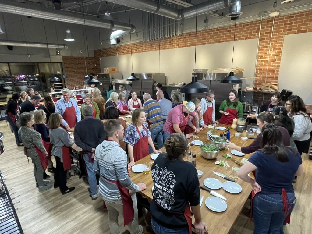 A corporate team gathered around the table during a hands-on cooking experience at The Local Epicurean in East Lansing.